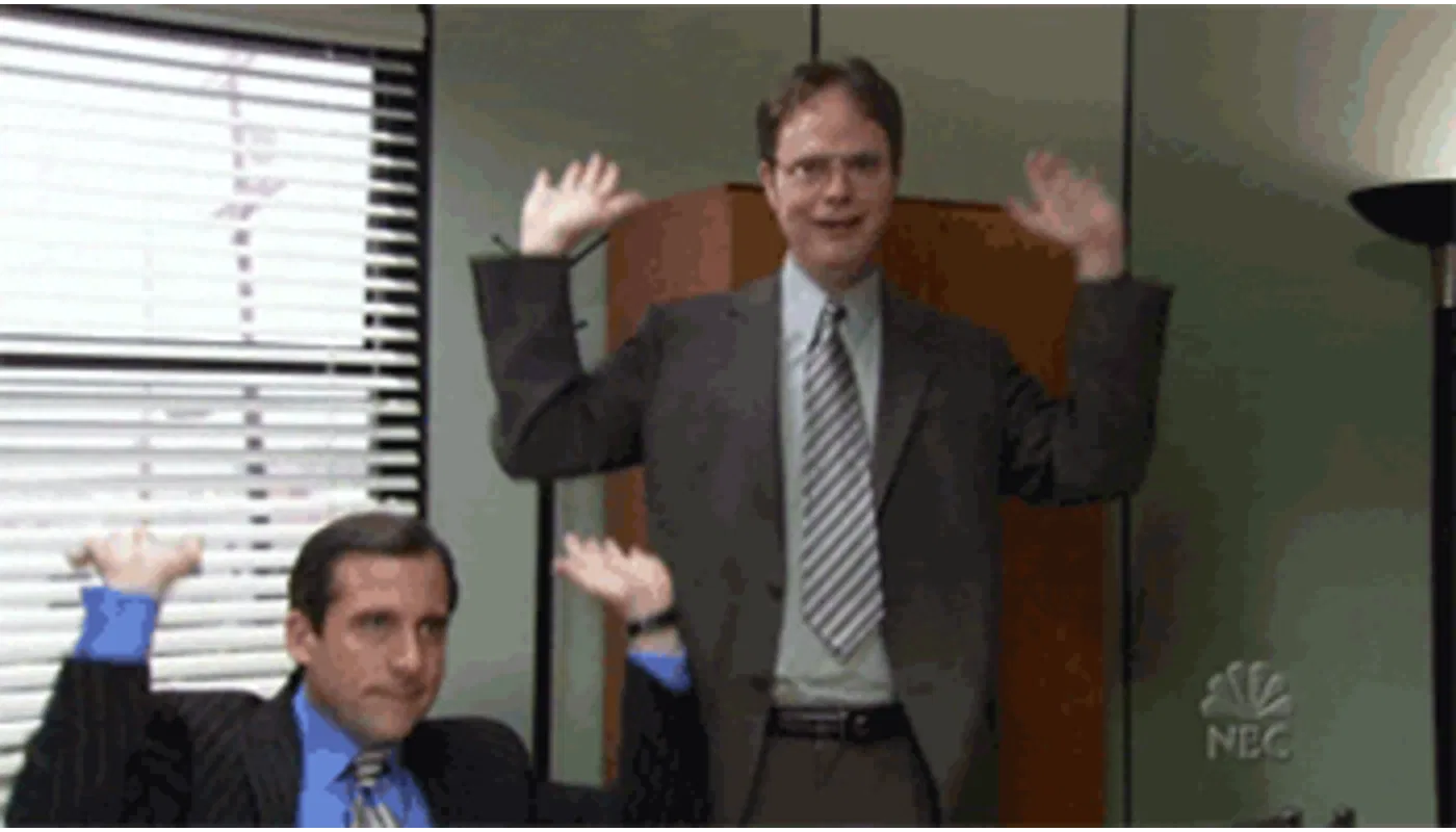 A gif with two people throwing their hands up in the air. 
